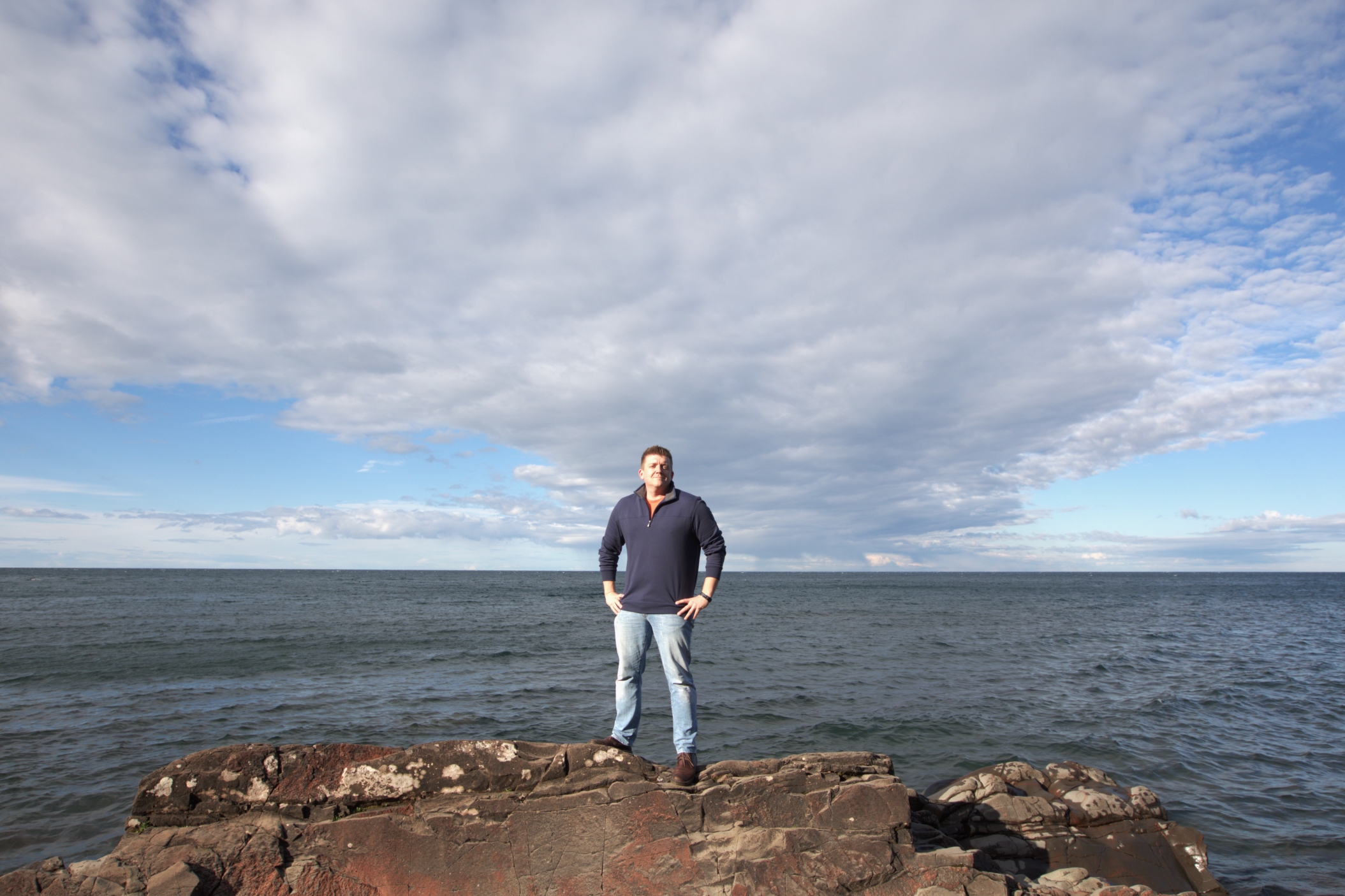 Phil standing on a rock along the shoreline of Lake Superior in the upper peninsula of Michigan